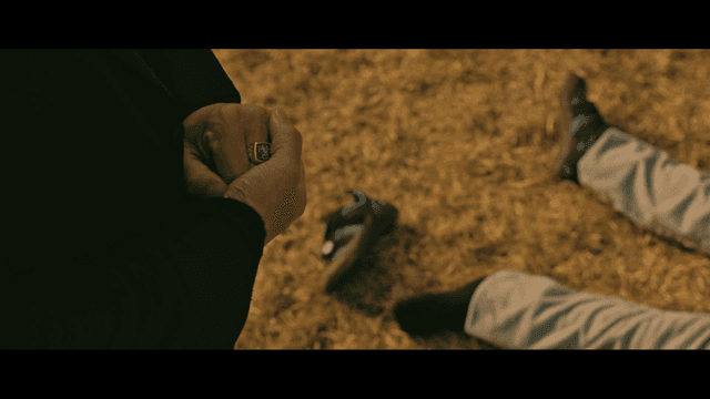 Person lying on grass and touching shoes and rings