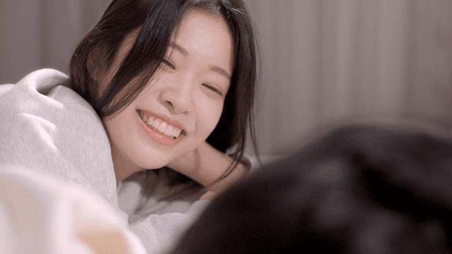 침대에 누워 따뜻하게 미소 지으며 남성을 바라보는 여성