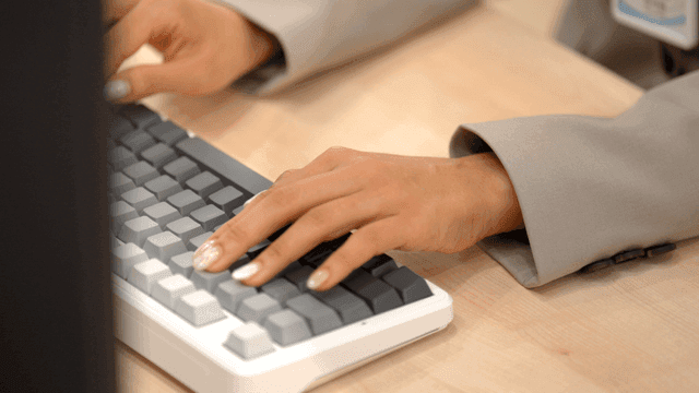 Hand of female office worker typing on keyboard in office