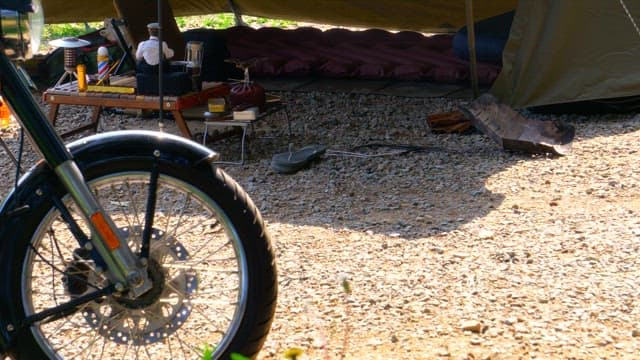 Campsite with motorbike and camping gear on a sunny day