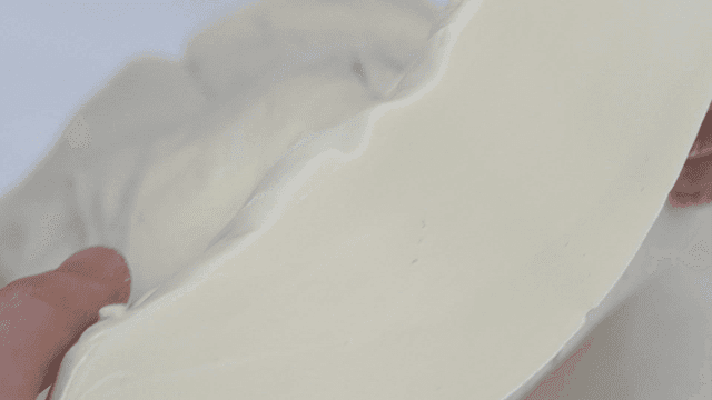 Hand holding a piece of dough