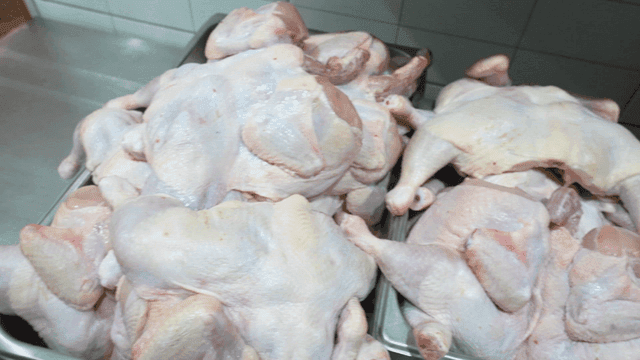 Raw chicken pieces filling metal bowl
