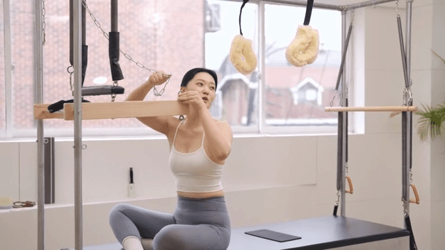 Woman setting up Pilates equipment indoors