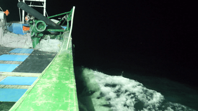 Fishing boat sailing at night