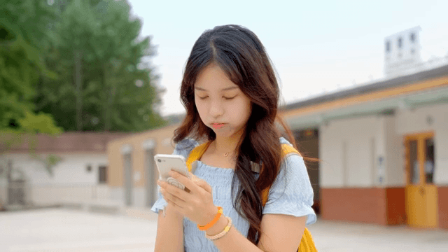Woman checking her phone at a train station