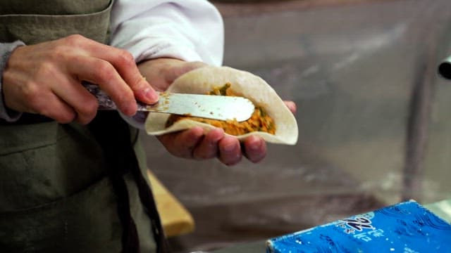 얇은 만두 피에 속을 넣어 김치만두를 준비하는 요리사