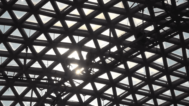 기하학적 유리 지붕 위의 작업자들