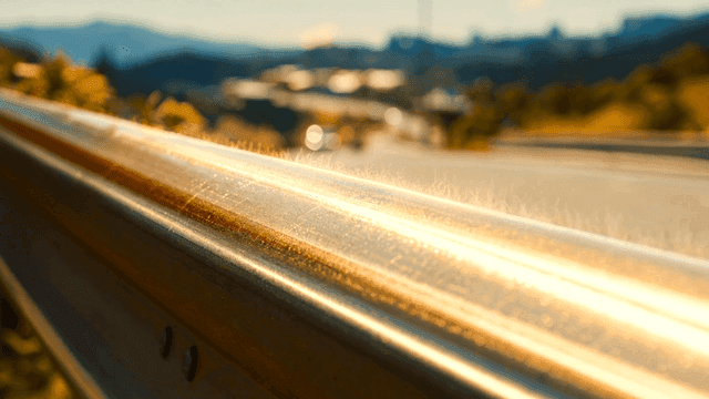 Sunlit highway and metal guardrails