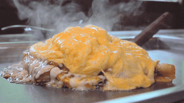 Steaming okonomiyaki omelet on hot iron plate