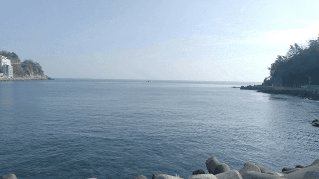 멀리 절벽과 배가 있는 잔잔한 바다