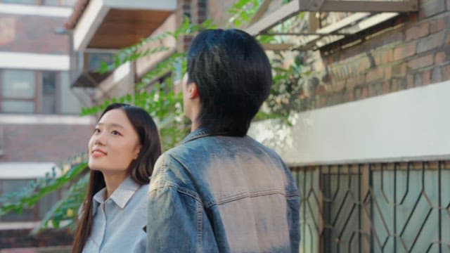 햇살이 비치는 골목에서 위를 바라보는 커플