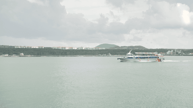 Ferry sailing near coastal breakwater