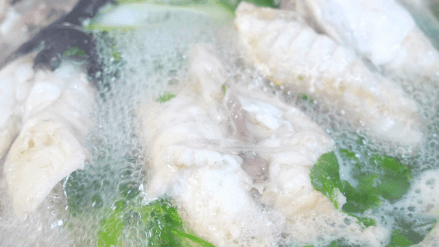Clear pufferfish soup boiling with vegetables