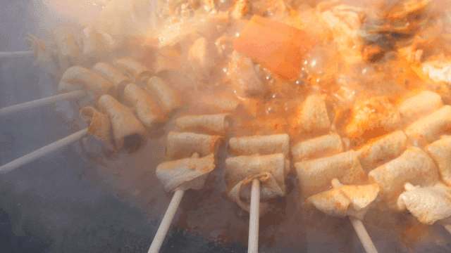 Fish cake skewers boiling in spicy broth