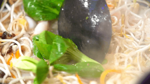 Stir-frying vegetables and seafood in a hot wok