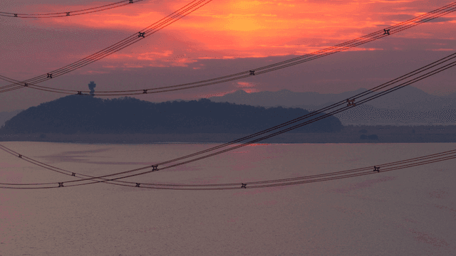 Sunset over a calm river with distant hills