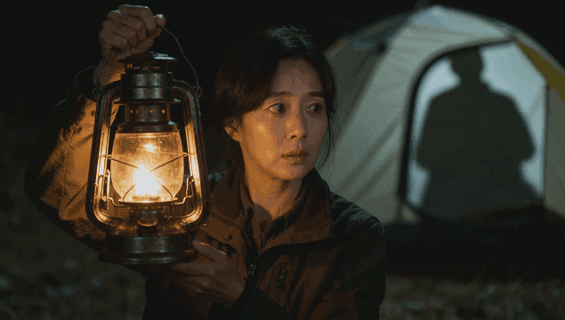 텐트에 비친 그림자와 랜턴을 들고 두리번대는 여성