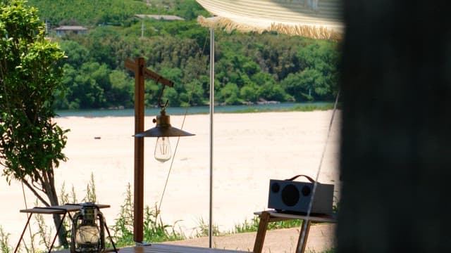 Riverside campsite with camping lanterns and tarps