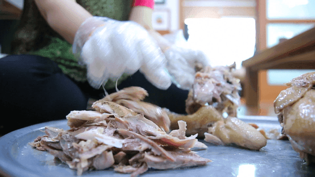 Person handling chicken by hand