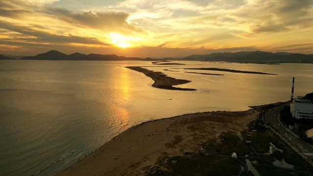 멀리 산이 보이는 해질녘의 고요한 해변