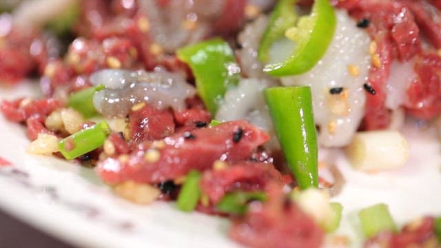 Fresh sliced octopus and beef tartare with green pepper