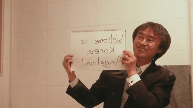 스케치북을 들고 거울 앞에서 연습하는 남자