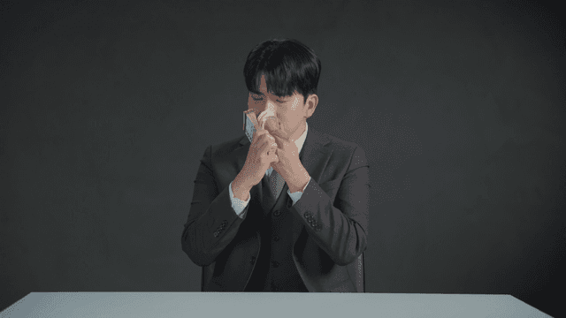 Man smelling money with a satisfied expression