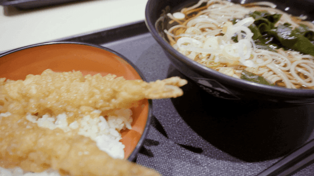 따뜻한 소바 국수와 새우 튀김이 있는 그릇