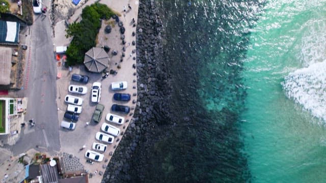 햇살 좋은 날 검은 돌로 이루어진 해안가 옆 길