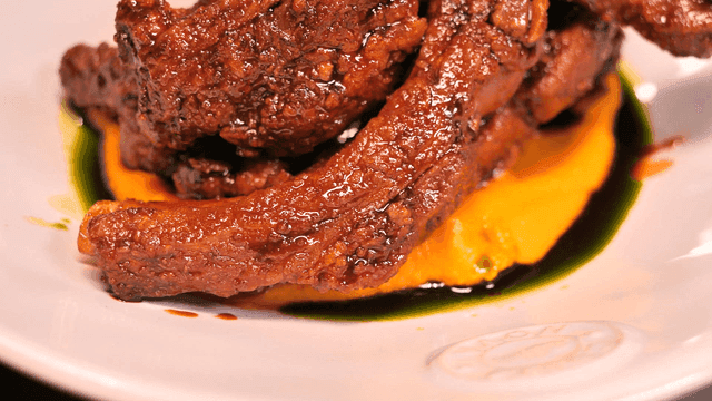 Juicy ribs served on plate with sauce