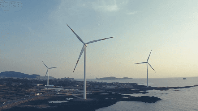 해질녘 바다 옆 풍력 터빈