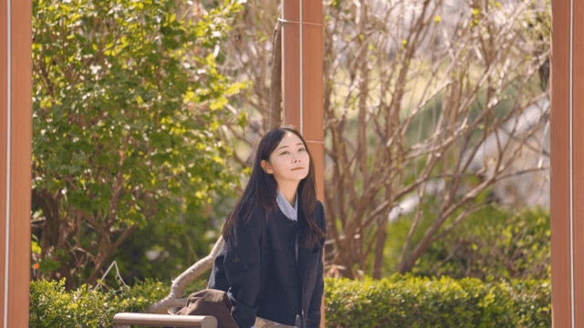 Woman sitting on park bench waiting for someone