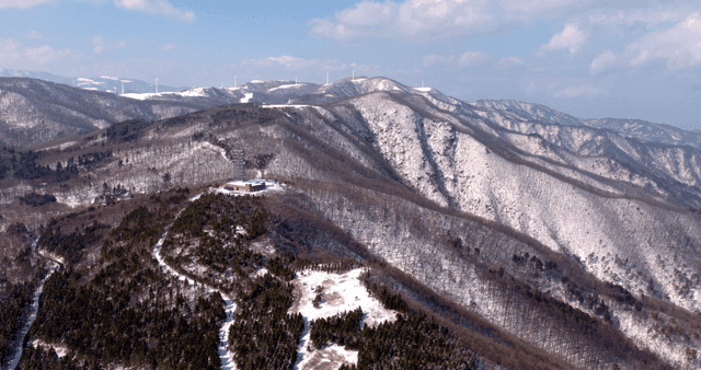 Snow-covered mountains with wind turbines