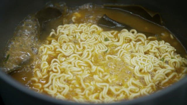 Ramen noodles boiling in a pot