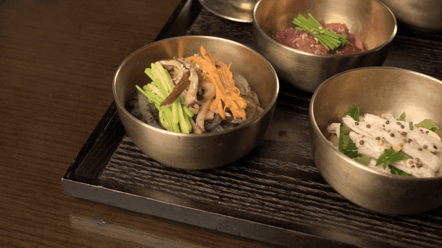 Korean side dishes served in rust-colored bowls