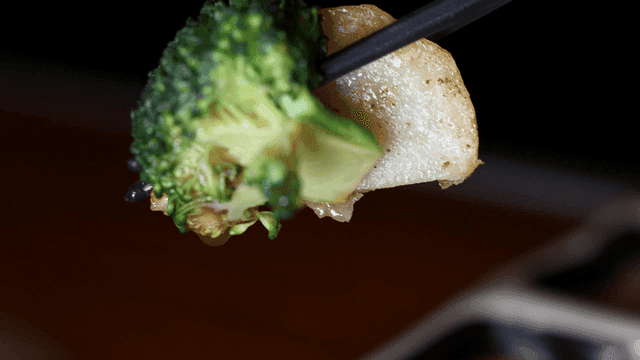 Chopsticks holding broccoli and potato