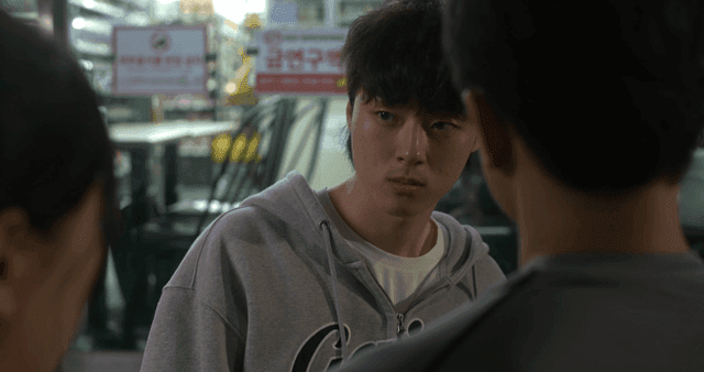 Young man getting angry at woman in front of convenience store at night