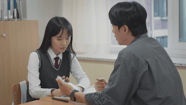 상담 중 학생을 위로하며 휴대폰을 확인하는 선생님