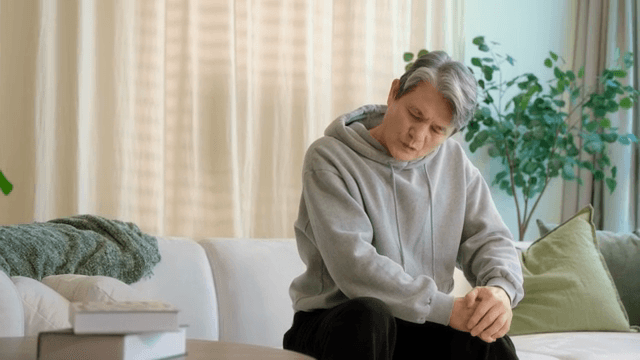 무릎을 잡고 불편해하는 남성