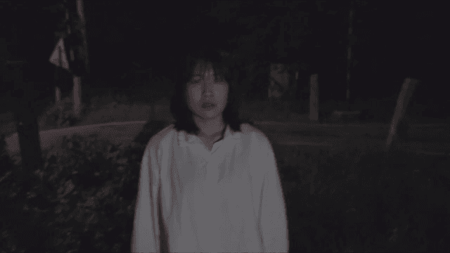 한 곳을 응시한 채 밤 길을 걷는 여성