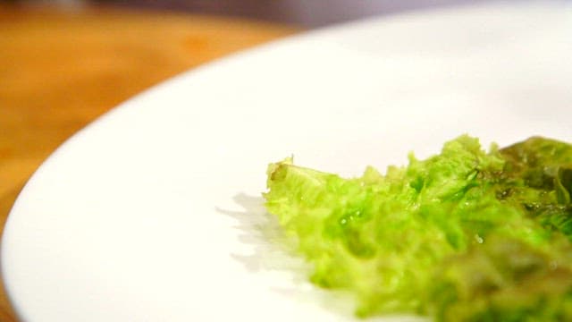 Spicy and sour swordtip squid salad being prepared on a plate