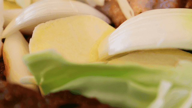 Dakgalbi topped with fresh vegetables and spicy sauce