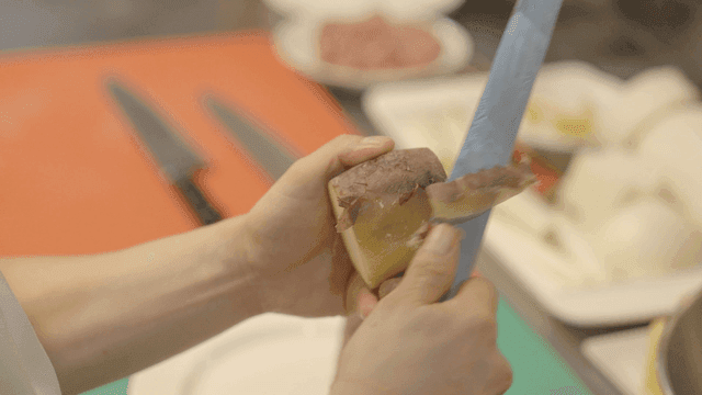 Peeling a sweet potato in the kitchen