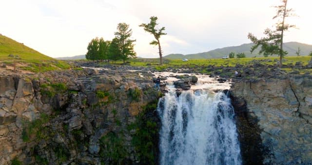 Scenic waterfall in a vast green landscape