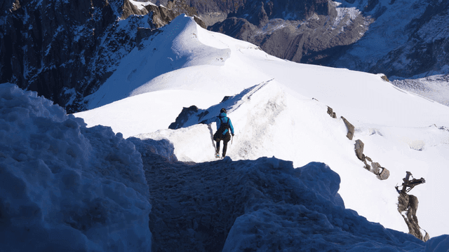 Hiker descending snow-covered ridge