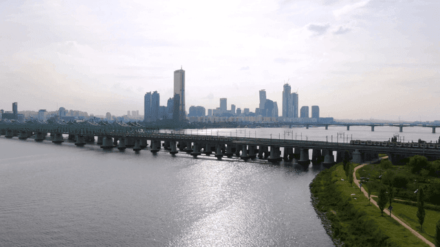 Railway bridge over river and city skyline