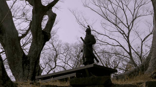 Statue of a warrior among bare trees