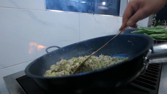 팬에서 다진 채소와 고기를 볶는 장면