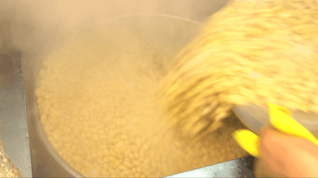 김이 나는 냄비에 콩을 붓는 장면