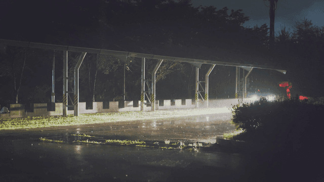 비 오는 도로를 비추는 자동차 헤드라이트